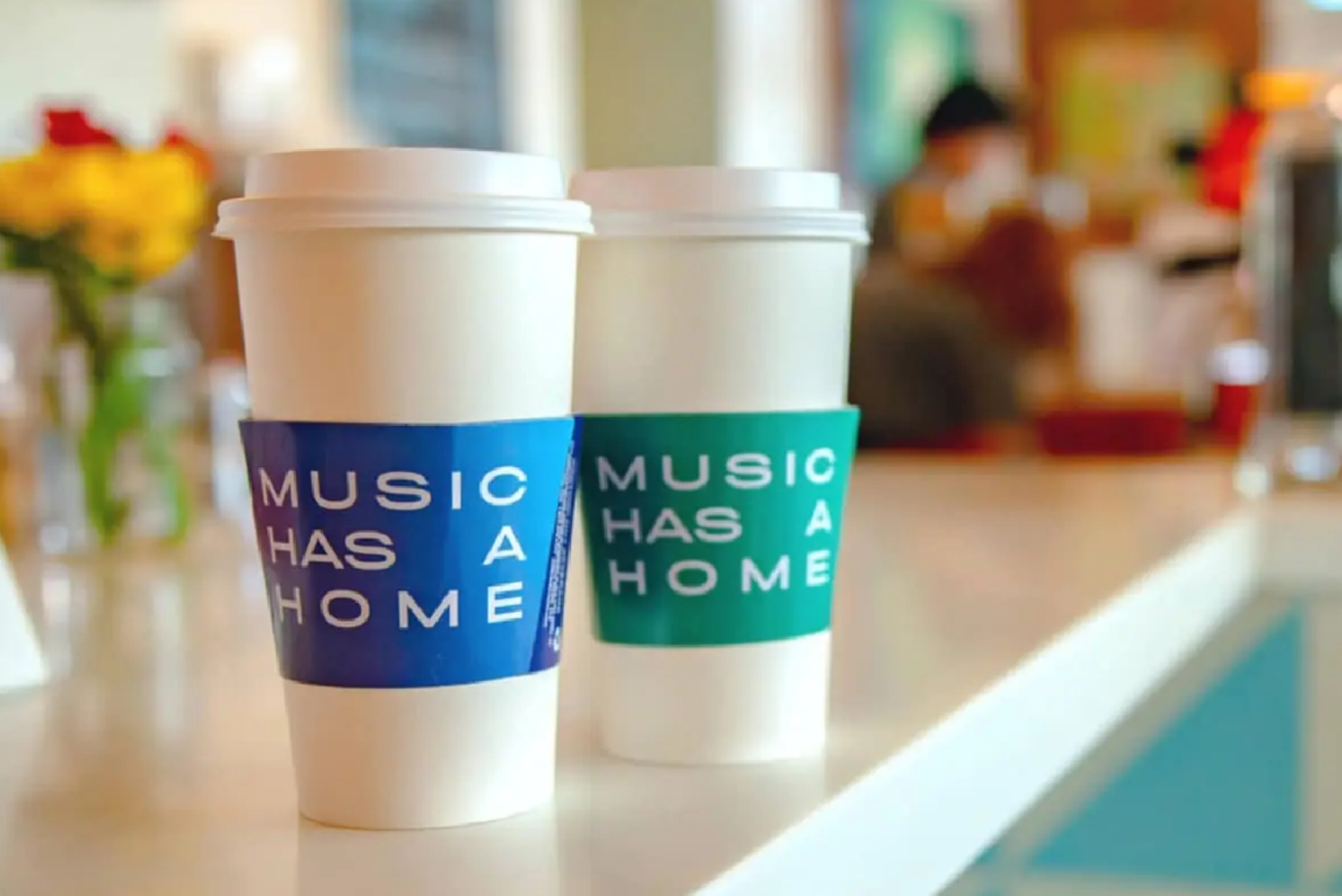 Branded coffee cup sleeves on coffee cups at cafe table