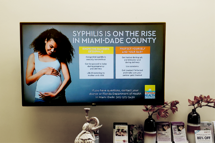 Commuters on subway platform with branded train advertisement